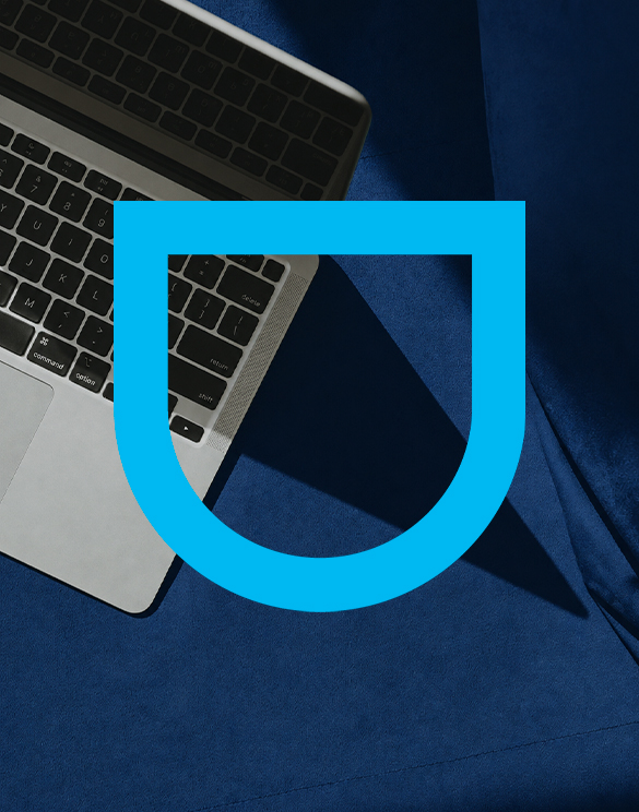 Brasão da DGA sobre uma mesa de trabalho com notebook
